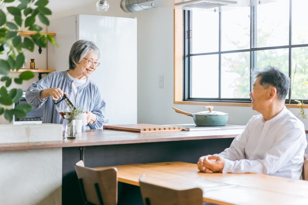 ダイニングキッチンで会話をする老夫婦