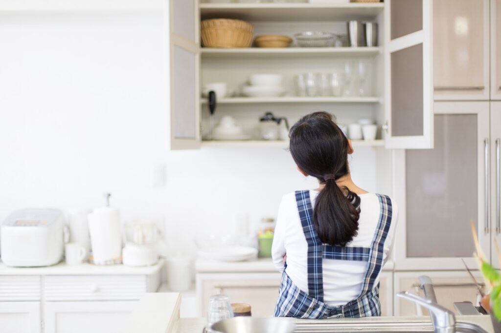 食器棚を開けて首をかしげる女性