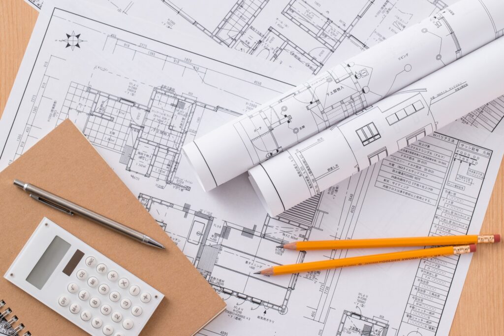 デスクの上の図面と筆記用具